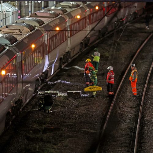 Emergency personnel inspect a train at the Huntingdon, England, train station in Cambridgeshire after people were stabbed Saturday, Nov. 1, 2025. (Chris Radburn/PA via AP)